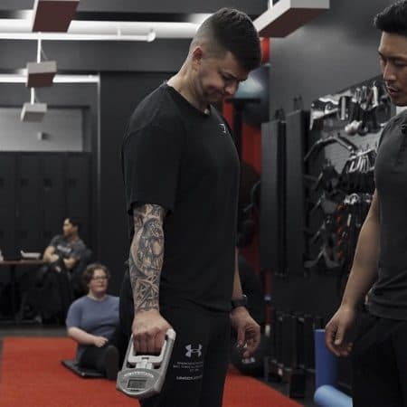 Arzadon Fitness certified trainer reviews body composition scan results with client during initial consultation at Toronto gym