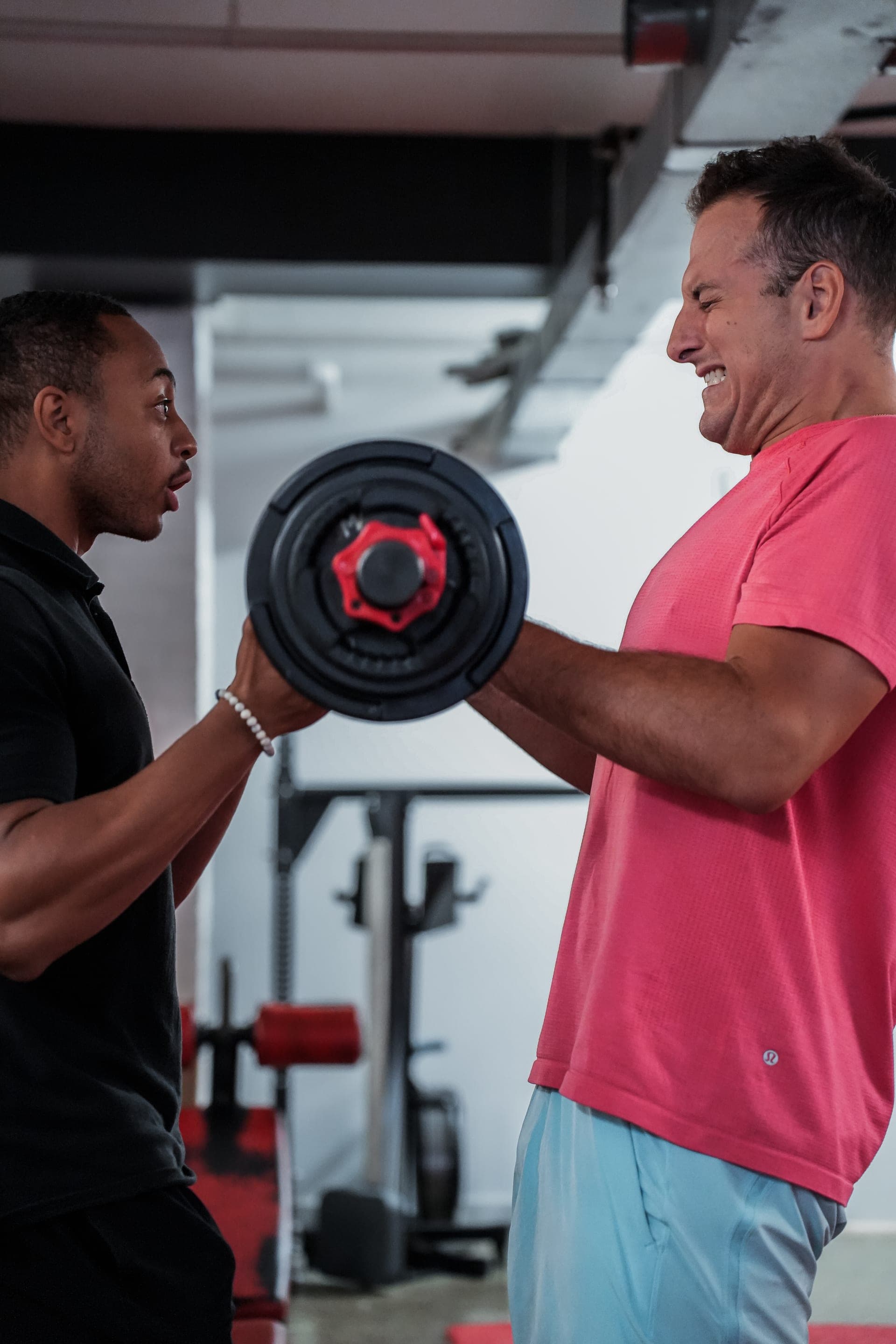 Trainer coaching client during heavy barbell lift at Arzadon Fitness Toronto