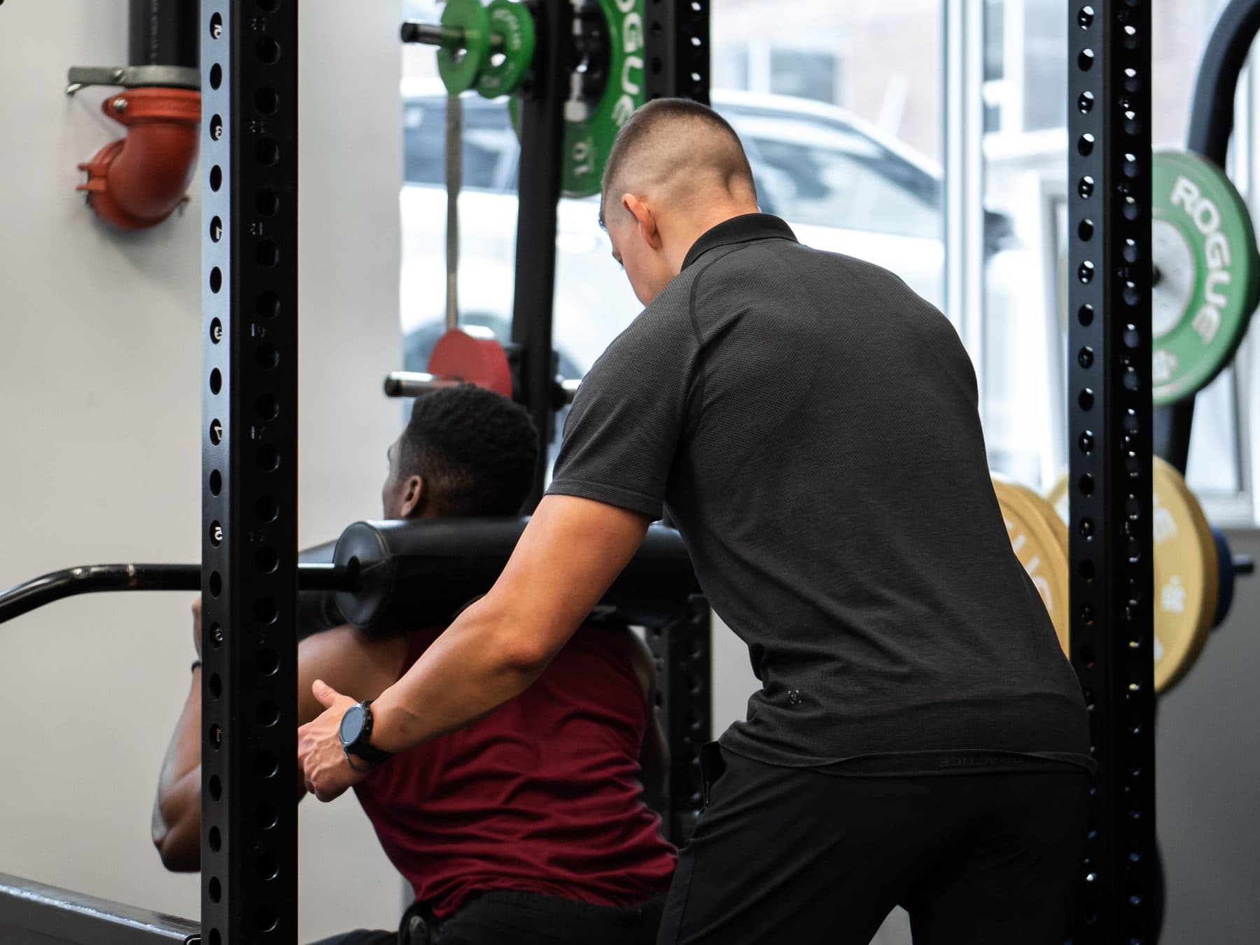 Personal trainer spotting a client through a loaded squat at Arzadon Fitness Toronto