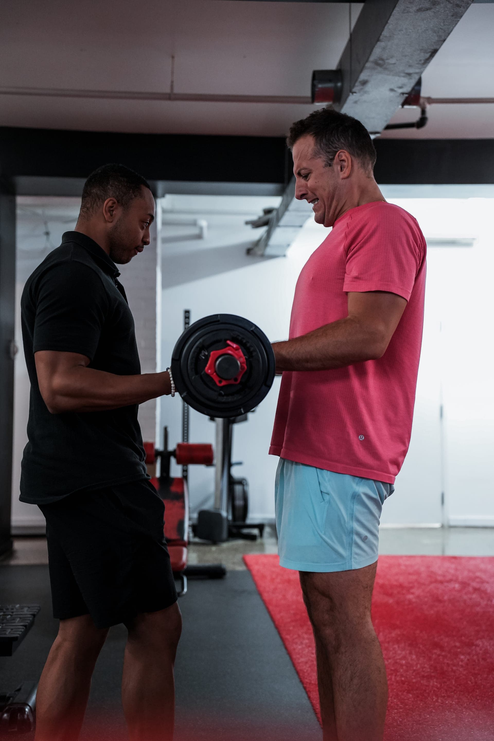 Personal trainer coaching client with barbell at Arzadon Fitness Toronto